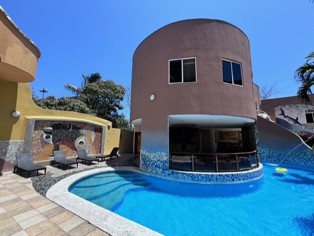 Hotel Katarma cylindrical tower with mosaic pool and lounge chairs